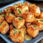 Close-up of Crispy Bang Bang Salmon Bites with a crispy golden coating and a side of dipping sauce.